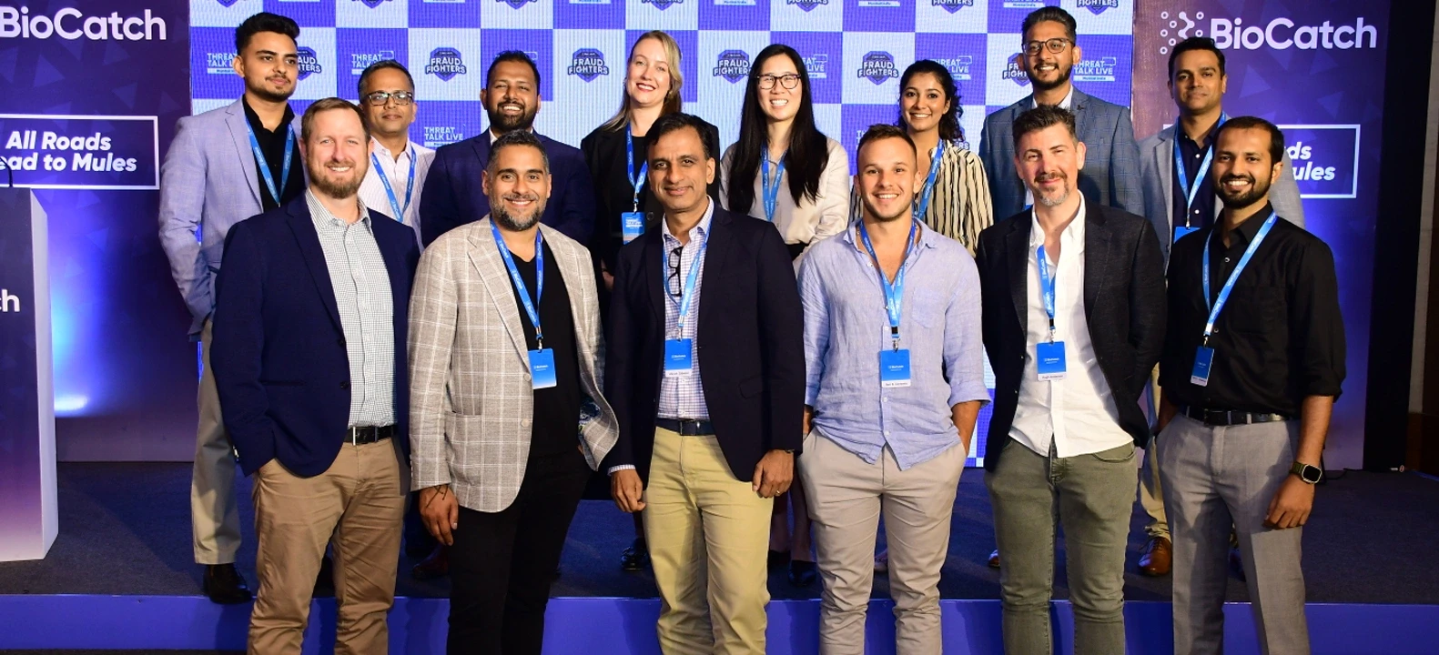 Team photo at corporate event with blue backdrop