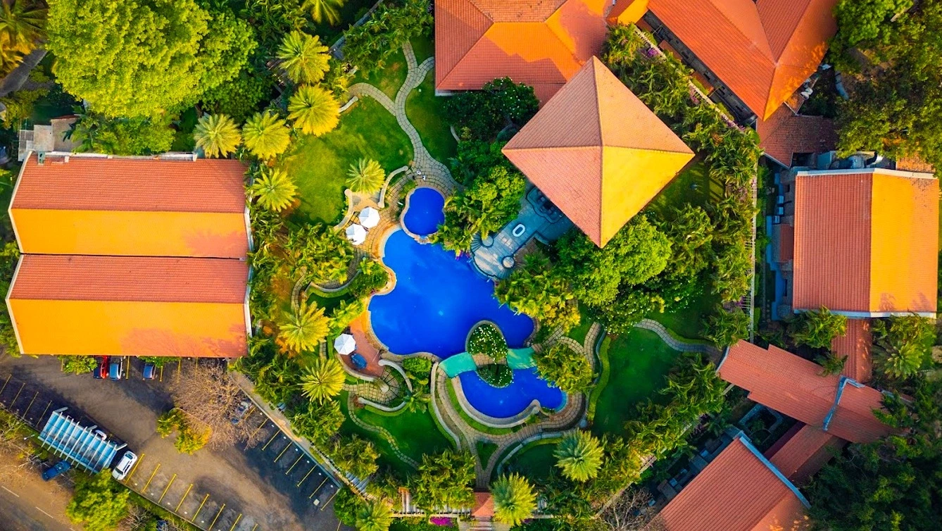 Aerial view of resort pool surrounded by greenery
